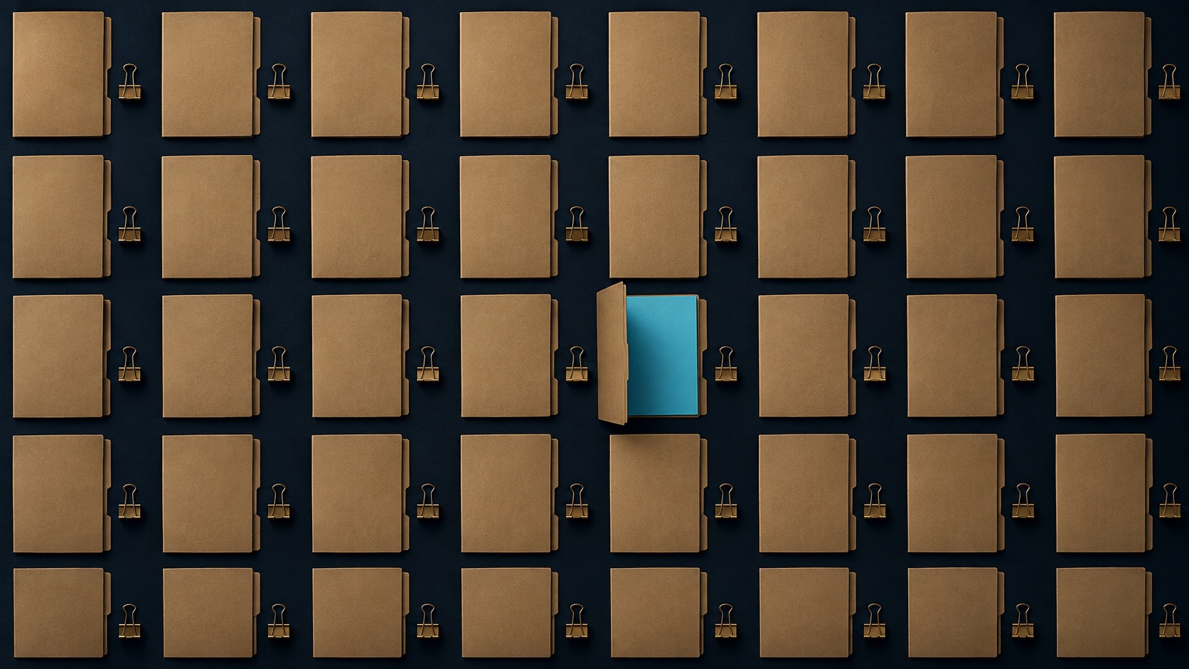 An overhead grid of plain document folders and brass clips with one open folder revealing a cyan sheet
